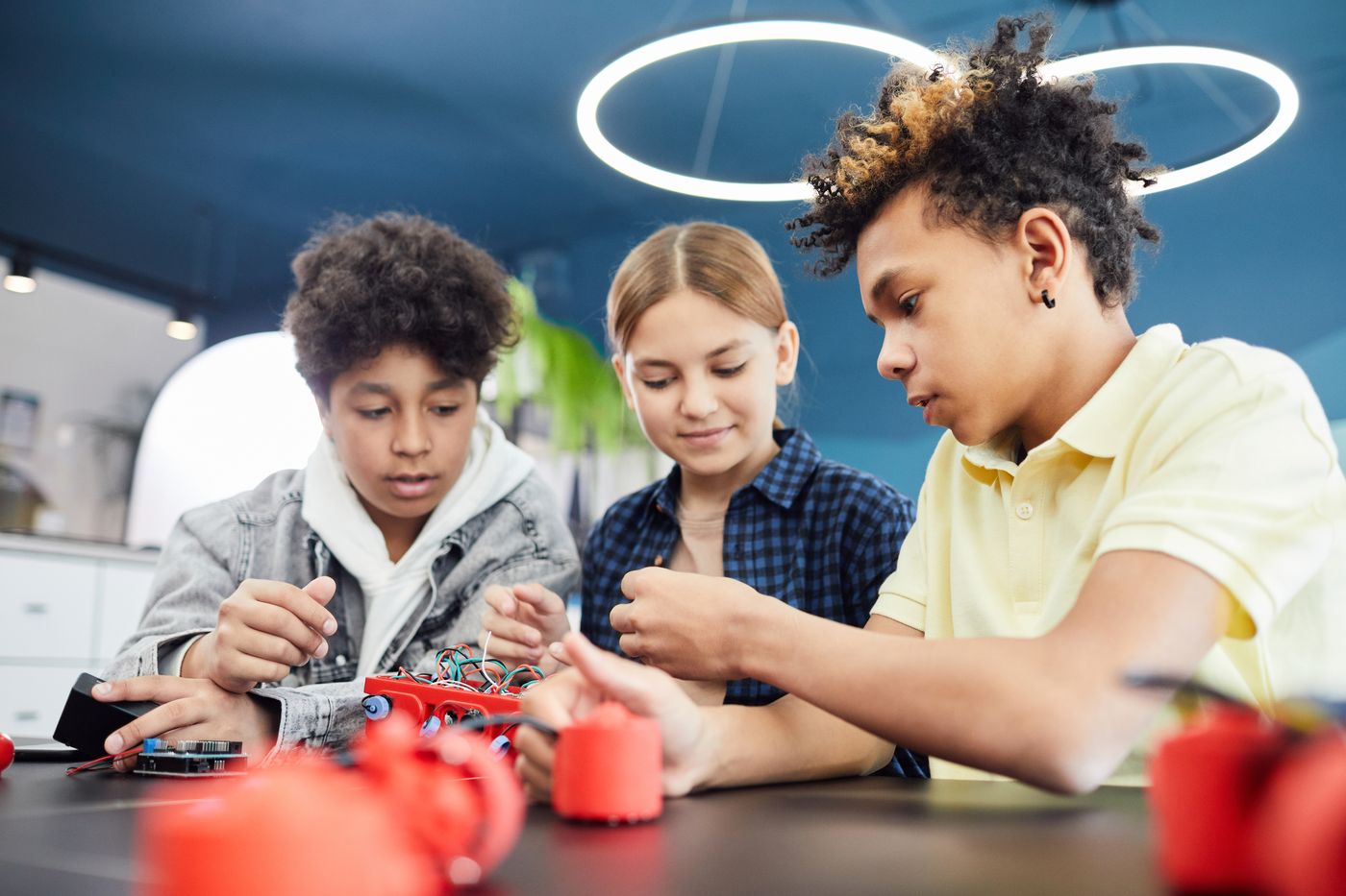 Three students working together to build and wire a robot